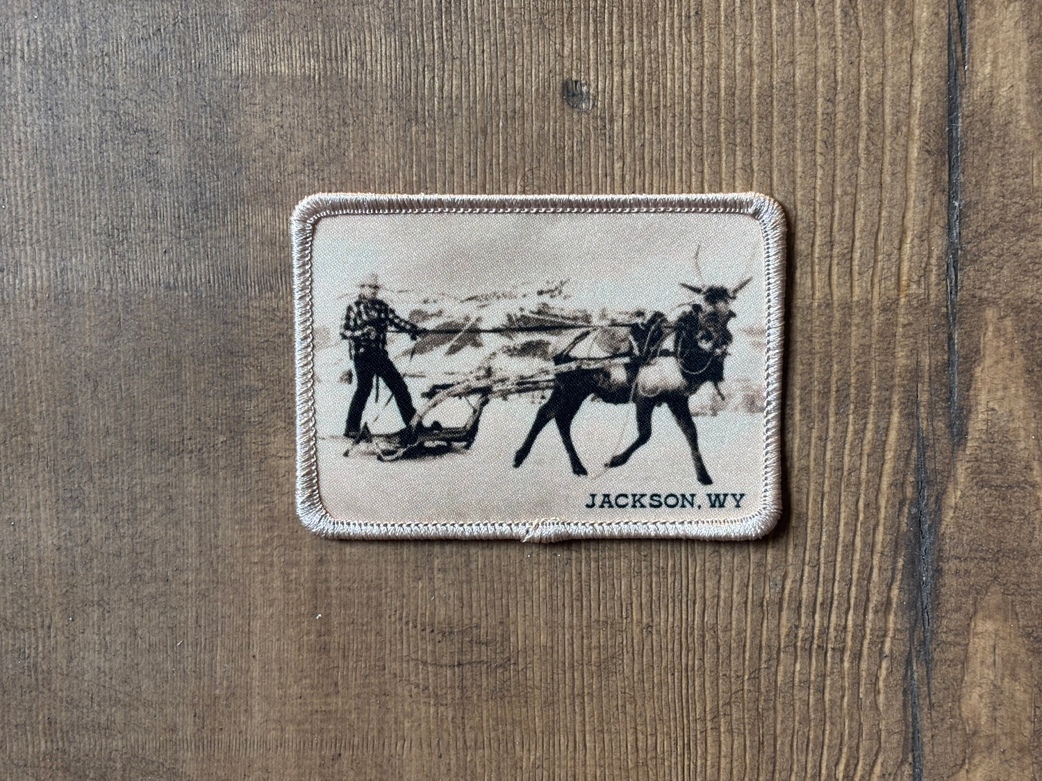 Patch showing Fuzzy the bull elk pulling a sleigh across the snow, Jackson Hole 1953