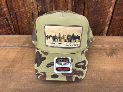 Trucker hat with riders and pack horses in snow, Gros Ventre Range